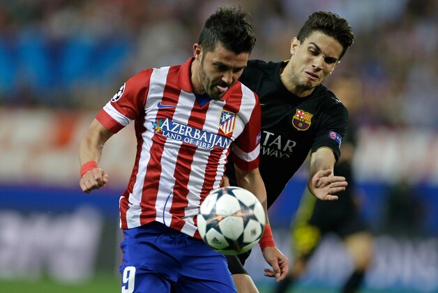 Atletico's David Villa, left, fights for the ball with  Barcelona's Marc Bartra during the Champions League quarterfinal second leg soccer match between Atletico Madrid and FC Barcelona in the Vicente Calderon stadium in Madrid, Spain, Wednesday, April 9, 2014. (AP Photo/Paul White)