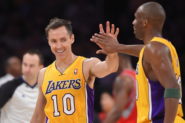 Los Angeles Lakers' Steve Nash, left, is congratulated by guard Jodie Meeks after Nash's assist to tie for third place in NBA career assists, during the first half of an NBA basketball game against the Houston Rockets, Tuesday, April 8, 2014, in Los Angeles. Meeks scored on the play. (AP Photo/Mark J. Terrill)