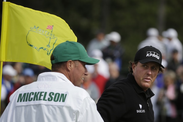 Phil Mickelson talks to his caddie Jim MacKay on the ninth hole during a practice round for the Masters golf tournament Tuesday, April 8, 2014, in Augusta, Ga. (AP Photo/Darron Cummings)