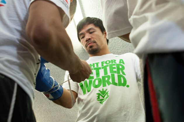 HOLLYWOOD, CA - APRIL 2:  Boxer Manny Pacquiao puts on his gloves during the media day workout at the Wild Card Boxing Gym on April 2, 2014 in Hollywood, California (Photo by Alexis Cuarezma/Getty Images)