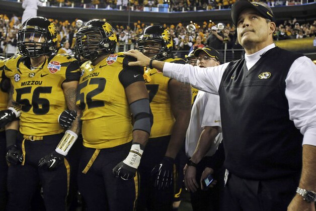 FILE - In this Jan. 3, 2014 file photo, Missouri head coach Gary Pinkel, right, and players, including offensive linesman Robert Luce (56) and defensive lineman Michael Sam (52), prepare to take the field for the Cotton Bowl NCAA college football game against Oklahoma State, in Arlington, Texas. Sam, Missouri's All-America defensive end came out to the entire country Sunday night, Feb. 9, 2014, and could become the first openly gay player in America's most popular sport. (AP Photo/Tim Sharp, File)