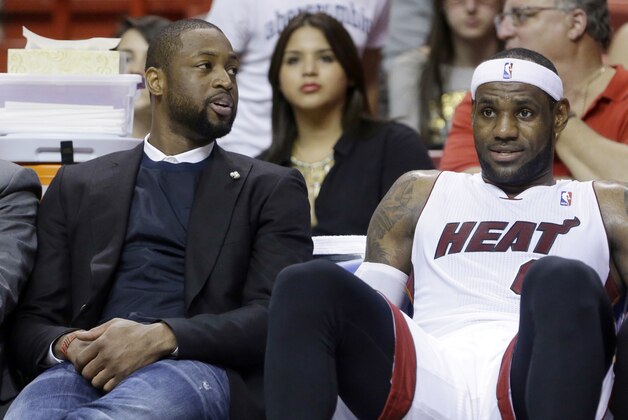Miami Heat guard Dwyane Wade, left, and forward LeBron James chat on the bench during the final seconds of an NBA basketball game against the New York Knicks, Sunday, April 6, 2014 in Miami. The Heat won 102-91. (AP Photo/Wilfredo Lee)