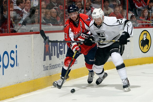 WASHINGTON, DC - MARCH 25:  Trevor Lewis #22 of the Los Angeles Kings and Mike Green #52 of the Washington Capitals battle for the puck in the first period during an NHL game at Verizon Center on March 25, 2014 in Washington, DC.  (Photo by Patrick McDermott/NHLI via Getty Images)
