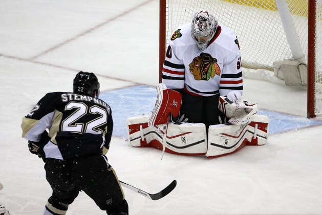 Pittsburgh Penguins' Lee Stempniak (22) puts the puck behind Chicago Blackhawks goalie Corey Crawford (50) for a goal in the first period of an NHL hockey game in Pittsburgh, Sunday, March 30, 2014. (AP Photo/Gene J. Puskar)