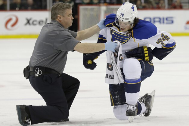 St. Louis Blues right wing T.J. Oshie (74) tries to get up with help from a trainer but can't after being injured during the second period of an NHL hockey game against the Minnesota Wild in St. Paul, Minn., Thursday, April 10, 2014. (AP Photo/Ann Heisenfelt)