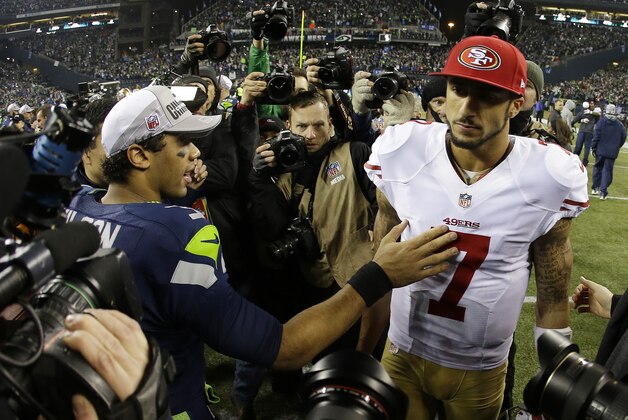 Seattle Seahawks' Russell Wilson, left, talks to San Francisco 49ers' Colin Kaepernick (7) after the NFL football NFC Championship game Sunday, Jan. 19, 2014, in Seattle. The Seahawks won 23-17 to advance to Super Bowl XLVIII. (AP Photo/Matt Slocum)
