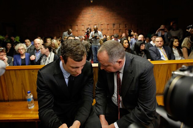 PRETORIA, SOUTH AFRICA - AUGUST 19:  South African athlete Oscar Pistorius (L) speaks with his lawyer Kenny Oldwage in Pretoria Magistrates Court prior to an indictment hearing on August 19, 2013 in Pretoria, South Africa. Pistorius, 26 is accused of murdering his girlfriend Reeva Steenkamp which Pistorius denies claiming he mistook Steenkamp for an intruder. The indictment was served and the trial date of March 3, 2014 has now been set.  (Photo by Jemal Countess/Getty Images)