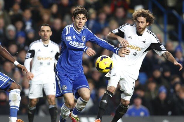 Chelsea's Oscar, left, of Brazil, controls the ball as Swansea City's Jose Canas, right, tries to stop him during an English Premier League soccer match against Swansea City at the Stamford Bridge ground in London, Thursday, Dec. 26, 2013. Chelsea won the match 1-0.(AP Photo/Lefteris Pitarakis)