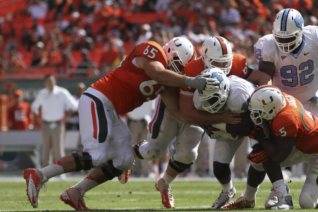 Miami's Brandon Linder (65), Shane McDermott (62) and Mike James (5) tackle North Carolina's Shakeel Rashad (42) as Sylvester Williams (92) applies pressure during the first half of a NCAA college football game in Miami, Saturday, Oct. 13, 2012. (AP Photo/J Pat Carter)
