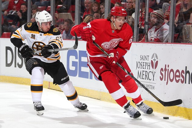 DETROIT, MI - APRIL 2:  Danny DeKeyser #65 of the Detroit Red Wings skates with the puck as Brad Marchand #63 of the Boston Bruins puts a stick on him during an NHL game on April 2, 2014 at Joe Louis Arena in Detroit, Michigan. (Photo by Dave Reginek/NHLI via Getty Images)