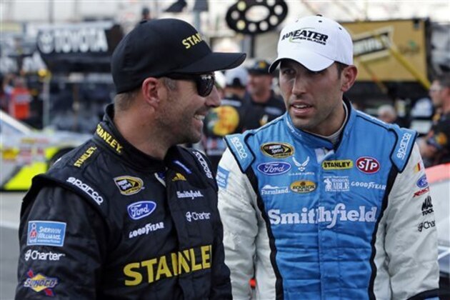 FILE - In this Aug. 23, 2013 file photo, Aric Almirola, right, talks with Marcos Ambrose during qualifying for the NASCAR Irwin Tools Night Race in Bristol, Tenn. In 75 races as teammates, Almirola and Ambrose had never before run in the top-five together. They finally broke through at Bristol Motor Speedway, where Richard Petty Motorsports scored its best overall day as an organization in years. (AP Photo/Wade Payne, File)