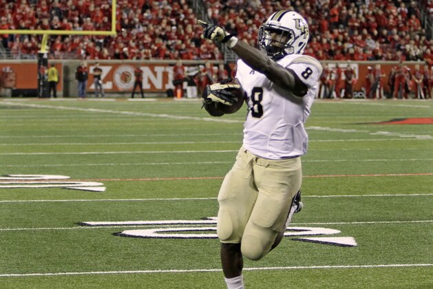 Central Florida running back Storm Johnson (8) celebrates as he scores untouched by Louisville defenders in the third quarter to tie the NCAA college football game in Louisville, Ky., Friday, Oct. 18, 2013. UCF came back to upset Louisville 38-35. (AP Photo/Garry Jones)