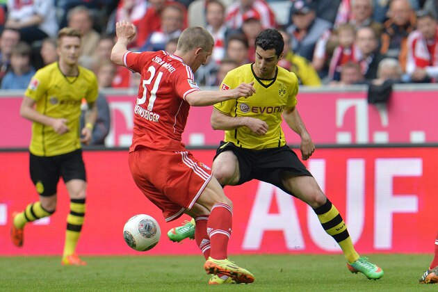 Bayern's Bastian Schweinsteiger, left, and Dortmund's Henrikh Mkhitaryan of Armenia challenge for the ball during the Bundesliga soccer match between FC Bayern Munich and Borussia Dortmund in Munich, Germany, on Saturday April 12, 2014. (AP Photo/Kerstin Joensson)