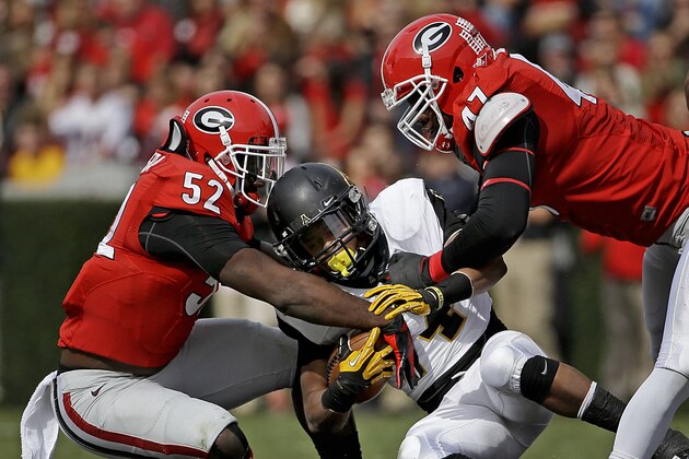Appalachian State's Marcus Cox, center, is tackled by Georgia's Amarlo Herrera, left, and Ray Drew in the first quarter of an NCAA college football game, Saturday, Nov. 9, 2013, in Athens, Ga. Georgia won 45-6. (AP Photo/David Goldman)