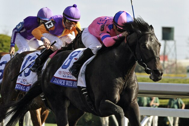 Jockey Corey Nakatani, right, rides Dance With Fate to victory over Medal Count, left, ridden by jockey Robby Albarado, in the Blue Grass Stakes horse race at Keeneland in Lexington, Ky., Saturday, April 12, 2014. (AP Photo/Garry Jones)