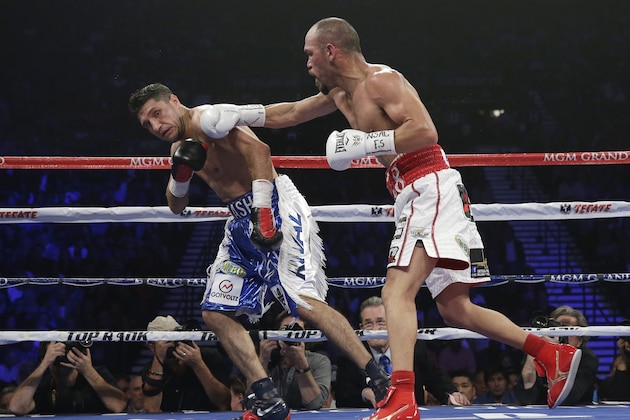 Raymundo Beltran, right, drives Canada's Arash Usmanee against the ropes in their WBO-NABF lightweight title boxing bout Saturday, April 12, 2014, in Las Vegas. (AP Photo/Isaac Brekken)