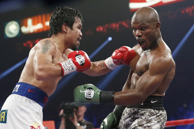 Manny Pacquiao, left, of the Philippines, throws a left at Timothy Bradley during the WBO welterweight title boxing bout Saturday, April 12, 2014, in Las Vegas. (AP Photo/Eric Jamison)
