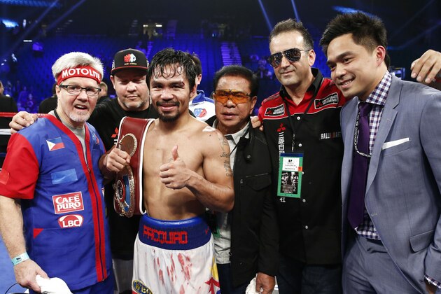 Manny Pacquiao, of the Philippines, along with his corner and trainer, Freddie Roach, left, celebrate his unanimous decision victory over Timothy Bradley just after their WBO World Welterweight championship boxing match, Saturday, April 12, 2014, at The MGM Grand Garden Arena in Las Vegas. (AP Photo/Eric Jamison)