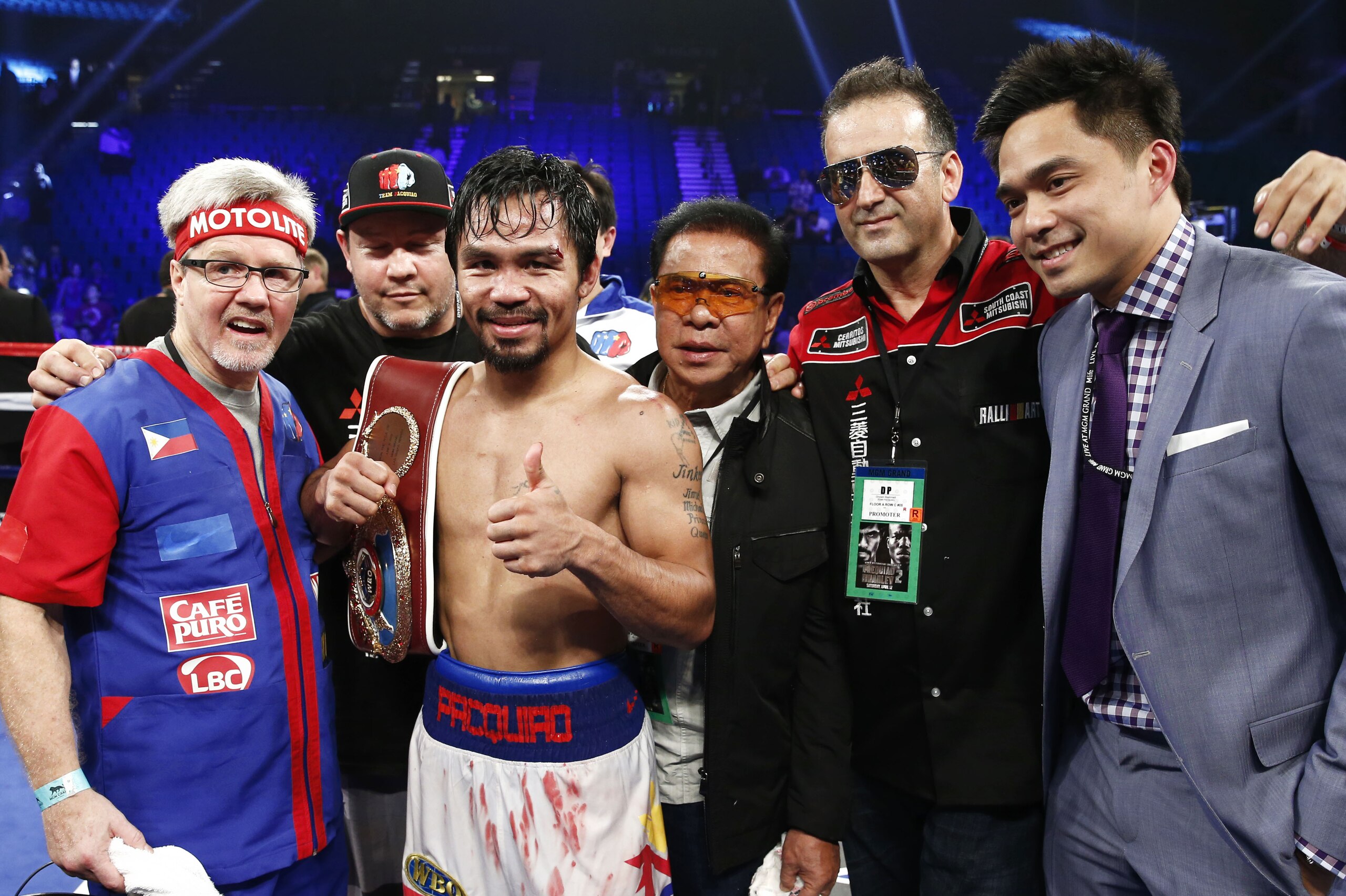 Manny Pacquiao, of the Philippines, along with his corner and trainer, Freddie Roach, left, celebrate his unanimous decision victory over Timothy Bradley just after their WBO World Welterweight championship boxing match, Saturday, April 12, 2014, at The MGM Grand Garden Arena in Las Vegas. (AP Photo/Eric Jamison)