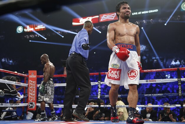 Manny Pacquiao, right, of the Philippines, and Timothy Bradley, are sent to their corners by referee Kenny Bayless at the end of a round of the WBO welterweight title boxing bout Saturday, April 12, 2014, in Las Vegas. (AP Photo/Eric Jamison)