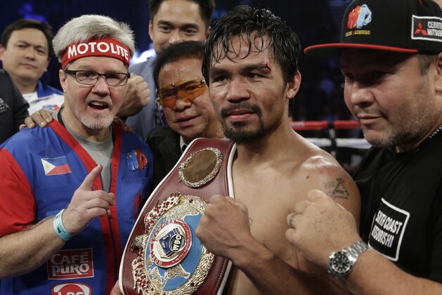 Manny Pacquiao, of the Philippines, center, is joined by trainer Freddie Roach, left, as he poses with the champion's belt following his unanimous decision against Timothy Bradley in their WBO welterweight title boxing fight Saturday, April 12, 2014, in Las Vegas. (AP Photo/Isaac Brekken)