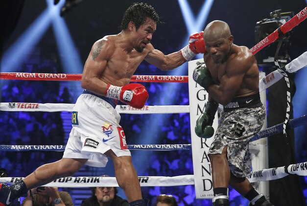 Manny Pacquiao, left, of the Philippines, drives Timothy Bradley into the ropes in their WBO welterweight title boxing bout Saturday, April 12, 2014, in Las Vegas. Pacquiao won by unanimous decision. (AP Photo/Isaac Brekken)