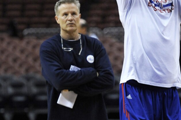 Philadelphia 76ers head coach Brett Brown, left, watches Nerlens Noel as he takes foul shots during warm ups before an NBA basketball against the Brooklyn Nets on Saturday, April 5, 2014, in Philadelphia. (AP Photo/Michael Perez)