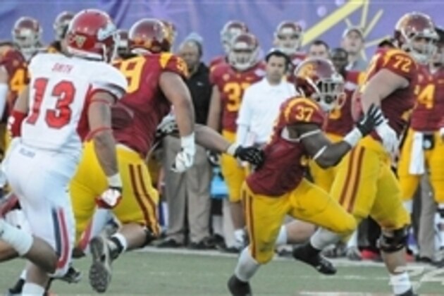 USC tailback Javorius Allen, right, is stopped after a long gain by Colorado defensive back Jered Bell in the third quarter of USC's 47-29 victory in an NCAA football game in Boulder, Colo., on Saturday, Nov. 23, 2013. (AP Photo/David Zalubowski)