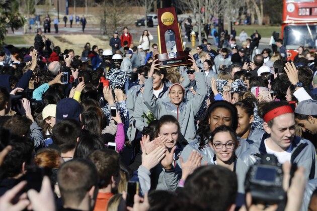 Connecticut women's basketball player Bria Hartley holds the championship trophy as she arrives with the team on campus for a rally celebrating their NCAA title, Wednesday, April 9, 2014, in Storrs, Conn. (AP Photo/Jessica Hill)