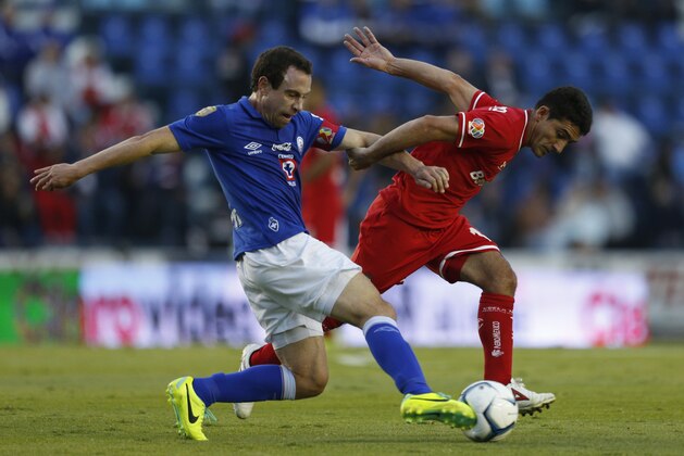 Cruz Azul's Gerardo Torrado, left, fights for the ball with Toluca's Antonio Naelson during a Mexican soccer league match in Mexico City, Saturday, Nov. 30, 2013. (AP Photo/Moises Castillo)
