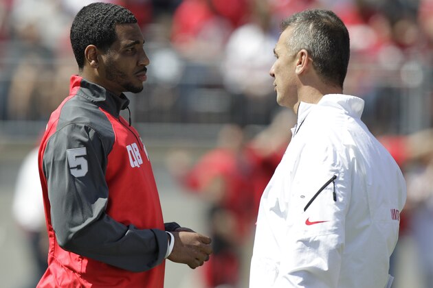 Ohio State quarterback Braxton Miller, left, talks with head coach Urban Meyer during their spring NCAA college football game Saturday, April 12, 2014, in Columbus, Ohio. (AP Photo/Jay LaPrete)