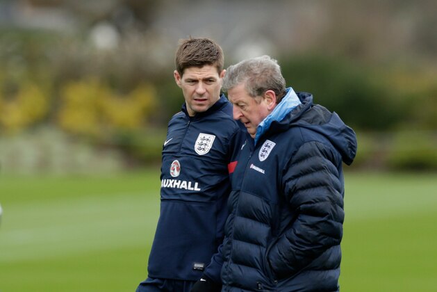 England captain Steven Gerrard, left, chats with manager Roy Hodgson during a national soccer squad training session at the training facilities of Tottenham Hotspur football club in Enfield, England, Monday, March 3, 2014. England play Denmark in an international friendly soccer match at Wembley stadium in London on Wednesday. (AP Photo/Matt Dunham)
