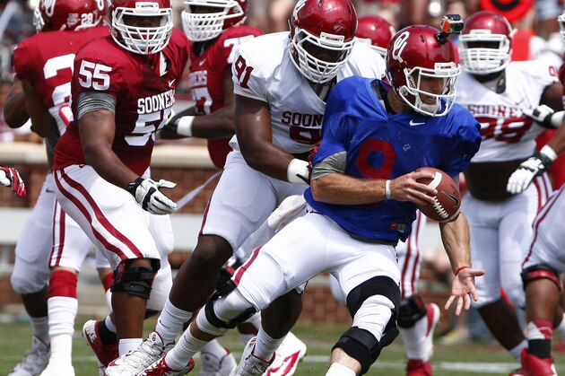 Oklahoma quarterback Trevor Knight (9) avoids a tackle during the annual NCAA college spring football game in Norman, Okla., Saturday, April 12, 2014. (AP Photo/Alonzo Adams)