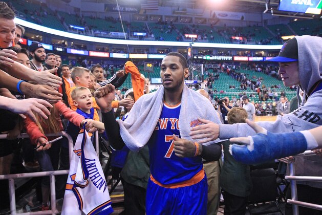 Fans reach for New York Knicks' Carmelo Anthony (7) as he walks off the court following their NBA basketball game against the Utah Jazz Monday, March 31, 2014, in Salt Lake City. The Knicks won 92-83. (AP Photo/Rick Bowmer)