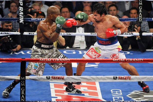 Timothy Bradley, left, and Manny Pacquiao, of the Philippines, trade blows in their WBO welterweight title boxing fight Saturday, April 12, 2014, in Las Vegas. (AP Photo/Isaac Brekken)
