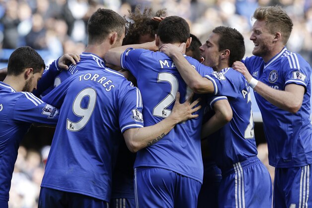 Chelsea's Mohamed Salah, hidden, is surrounded by team mates as he celebrates scoring a goal during the English Premier League soccer match between Chelsea and Arsenal at Stamford Bridge stadium in London, Saturday, March 22, 2014. (AP Photo/Kirsty Wigglesworth)