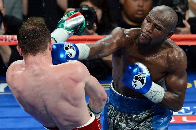 LAS VEGAS, NV - SEPTEMBER 14:  Floyd Mayweather Jr. (R) hits Canelo Alvarez in the seventh round of their WBC/WBA 154-pound title fight at the MGM Grand Garden Arena on September 14, 2013 in Las Vegas, Nevada. Mayweather won by majority decision.  (Photo by Ethan Miller/Getty Images)