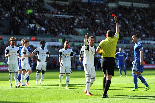 SWANSEA, WALES - APRIL 13:  Pablo Hernandez of Swansea remonstrates with Referee Phil Dowd as he shows the red card to Chico Flores (L) of Swansea during the Barclays Premier League match between Swansea City and Chelsea at Liberty Stadium on April 13, 2014 in Swansea, Wales.  (Photo by Chris Brunskill/Getty Images)