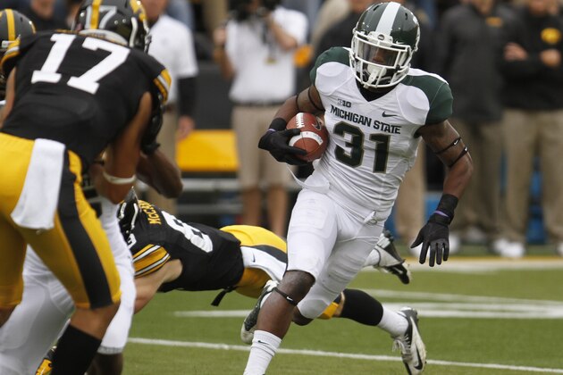 IOWA CITY, IOWA - OCTOBER 5:  Cornerback Darqueze Dennard #31 of the Michigan State Spartans runs back an interception up field during the first quarter in front of wide receiver Riley McCarron #83 of the Iowa Hawkeyes on October 5, 2013 at Kinnick Stadium in Iowa City, Iowa. Michigan State won 26-14. (Photo by Matthew Holst/Getty Images)