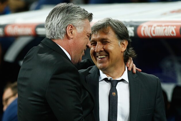 MADRID, SPAIN - MARCH 23: Carlo Ancelotti, coach of Real Madrid greets Gerardo Martino, coach of Barcelona during the La Liga match between Real Madrid CF and FC Barcelona at the Bernabeu on March 23, 2014 in Madrid, Spain.  (Photo by Gonzalo Arroyo Moreno/Getty Images)