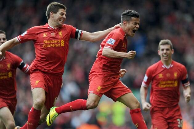 Liverpool's Philippe Coutinho right, celebrates with team-mate Steven Gerrard left, after he scores the third goal of the game for his side during their English Premier League soccer match against Manchester City at Anfield in Liverpool, England, Sunday April. 13, 2014. (AP Photo/Clint Hughes)