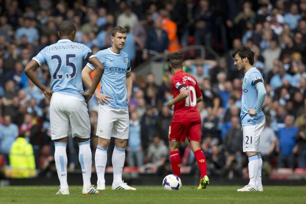Manchester City's David Silva, right, Edin Dzeko, centre left, and Fernandinho wait for play to begin after Liverpool's second goal during their English Premier League soccer match at Anfield Stadium, Liverpool, England, Sunday April 13, 2014. Liverpool won the game 3-2 with the winning goal scored by Philippe Coutinho, centre right. (AP Photo/Jon Super)
