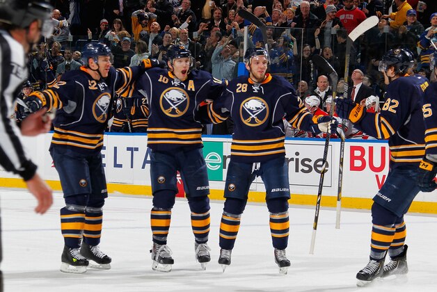 BUFFALO, NY - FEBRUARY 25: Christian Ehrhoff #10 of the Buffalo Sabres celebrates his game-winning goal with teammates Alexander Sulzer #52, Zemgus Girgensons #28 and Marcus Foligno #82 in their 3-2 win against the Carolina Hurricanes on February 25, 2014 at the First Niagara Center in Buffalo, New York.  (Photo by Bill Wippert/NHLI via Getty Images)