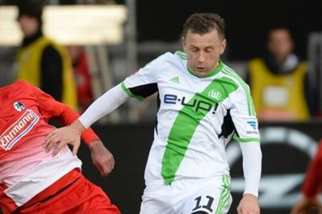 Freiburg's  Pavel Krmas , left, challenges for the ball with Wolfsburg's  Ivica Olic, during the German first division Bundesliga soccer match between SC Freiburg and VfL Wolfsburg in Freiburg, Germany Sunday Dec. 8, 2013. (AP Photo/dpa, Patrick Seeger)