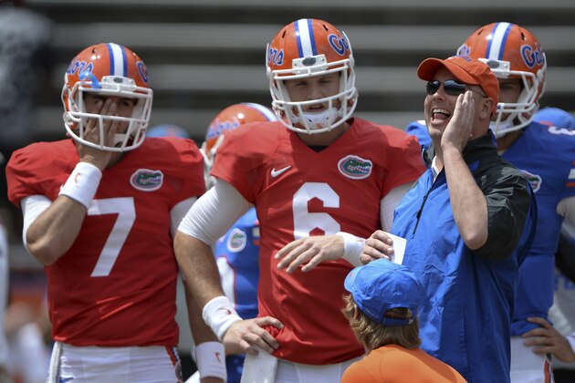 Florida's new Offensive Coordinator Kurt Roper, right, calls out instructions as he works with quarterbacks Will Grier (7) and Jeff Driskel (6) prior to the University of Florida's 2014 Orange & Blue Debut football game Saturday, April 12, 2014 in Gainesville, Fla.  (AP Photo/Phil Sandlin)