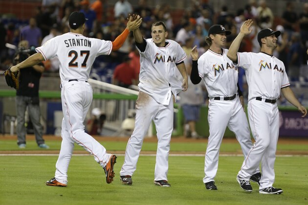 Miami Marlins starting pitcher Jose Fernandez, second from left, high fives right fielder Giancarlo Stanton (27) after the Marlins defeated the Cleveland Indians 10-0 in a baseball game, Friday, Aug. 2, 2013 in Miami. (AP Photo/Wilfredo Lee)