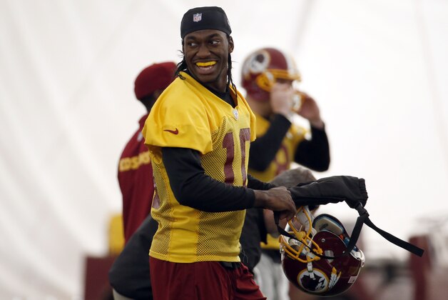 Washington Redskins quarterback Robert Griffin III smiles during their NFL football practice Wednesday, Dec. 11, 2013, in Ashburn, Va. Kirk Cousins will start for the Washington Redskins on Sunday, and Robert Griffin III will be the No. 3 quarterback behind Rex Grossman. (AP Photo/Alex Brandon)