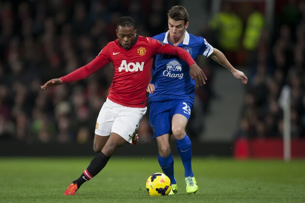 Manchester United's Patrice Evra, left, fights for the ball with Everton's Seamus Coleman during their English Premier League soccer match at Old Trafford Stadium, Manchester, England, Wednesday Dec. 4, 2013. (AP Photo/Jon Super)