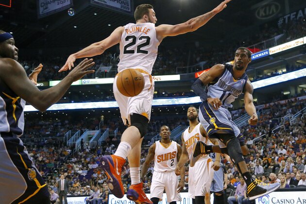 Memphis Grizzlies' Mike Conley (11) dishes off around Phoenix Suns' Miles Plumlee (22) to teammate Zach Randolph during the first half of an NBA basketball game, Monday, April 14, 2014, in Phoenix. (AP Photo/Matt York)