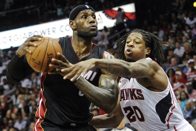 Miami Heat forward LeBron James, left, tries to keep the ball away from the defense of Atlanta Hawks forward Cartier Martin (20) during the second half of an NBA basketball game on Saturday, April 12, 2014, in Atlanta. Atlanta won 98-85. (AP Photo/John Amis)